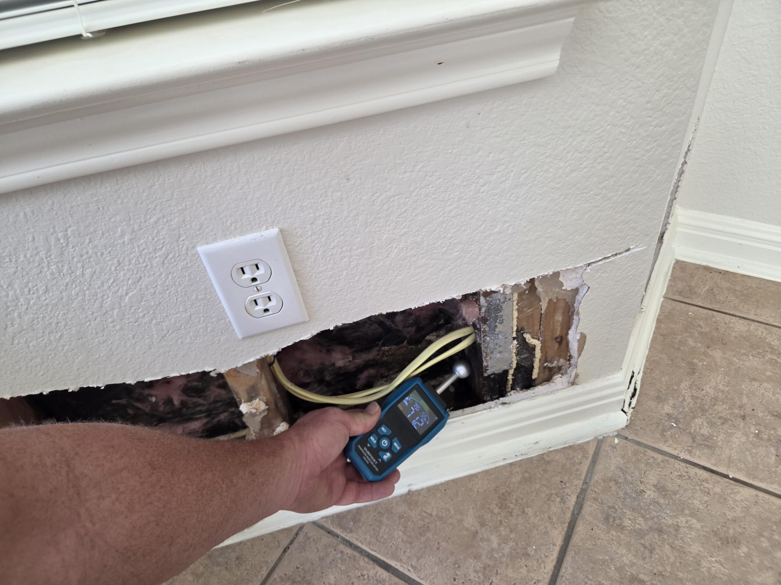 Restoration technician operating professional drying equipment inside a water-damaged Austin home
